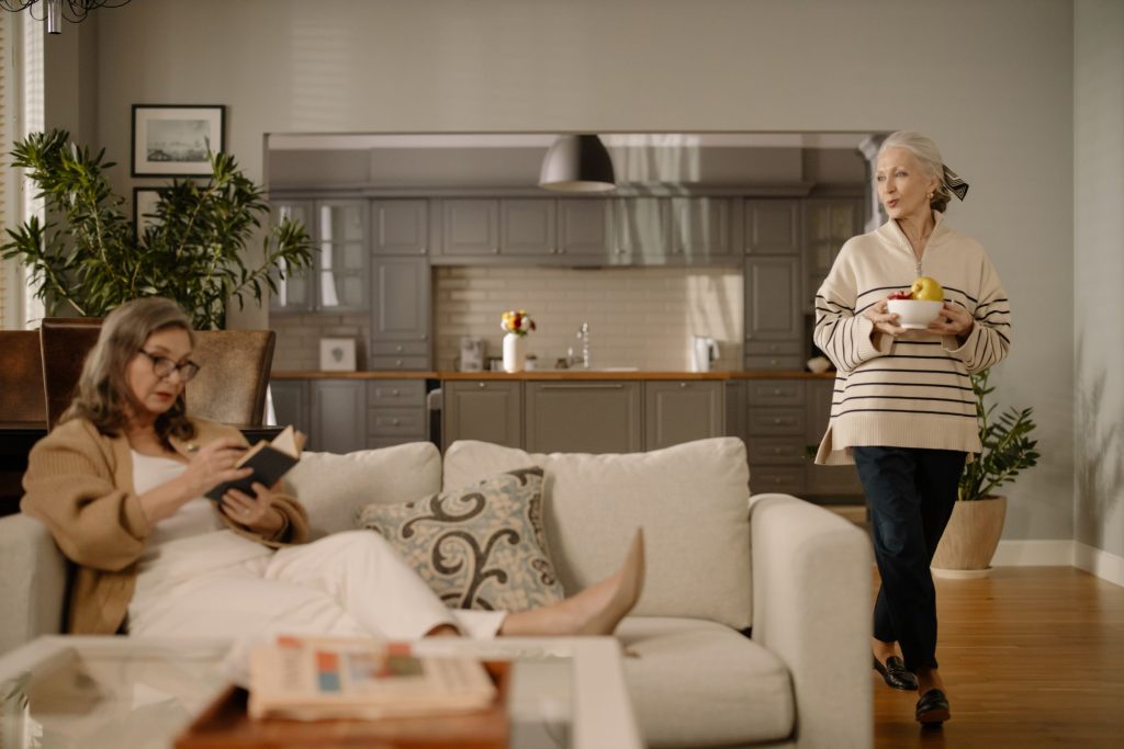 Pflegekraft hilft einer Seniorin beim Ankleiden